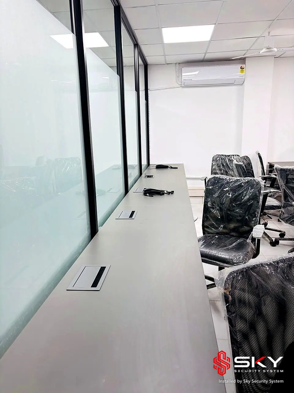 Glass-partitioned workspace at a corporate office. Security and ELV work by Sky Security System.