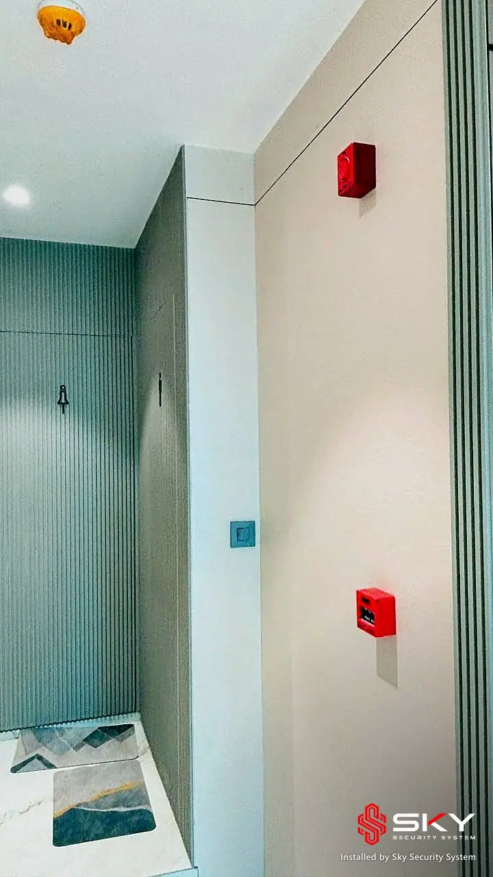 Corridor with a fire alarm call point at a corporate office. Security and ELV work by Sky Security System.