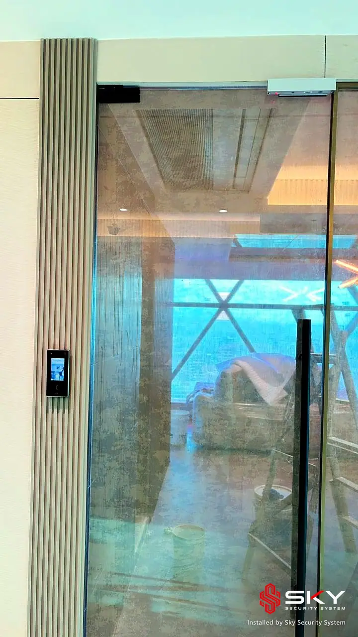 Glass door with an access control reader at a corporate office. Security and ELV work by Sky Security System.