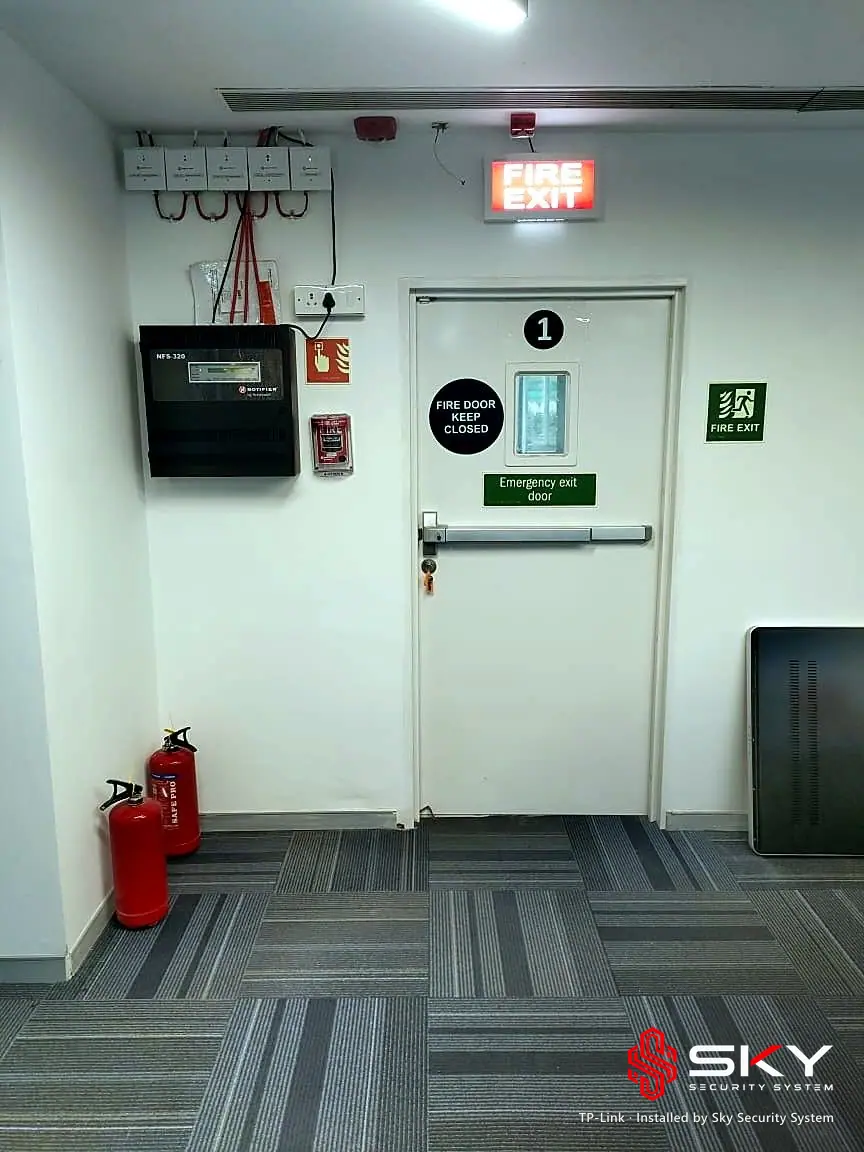 Fire exit with panel and extinguishers at the TP-Link site. Security and ELV work by Sky Security System.