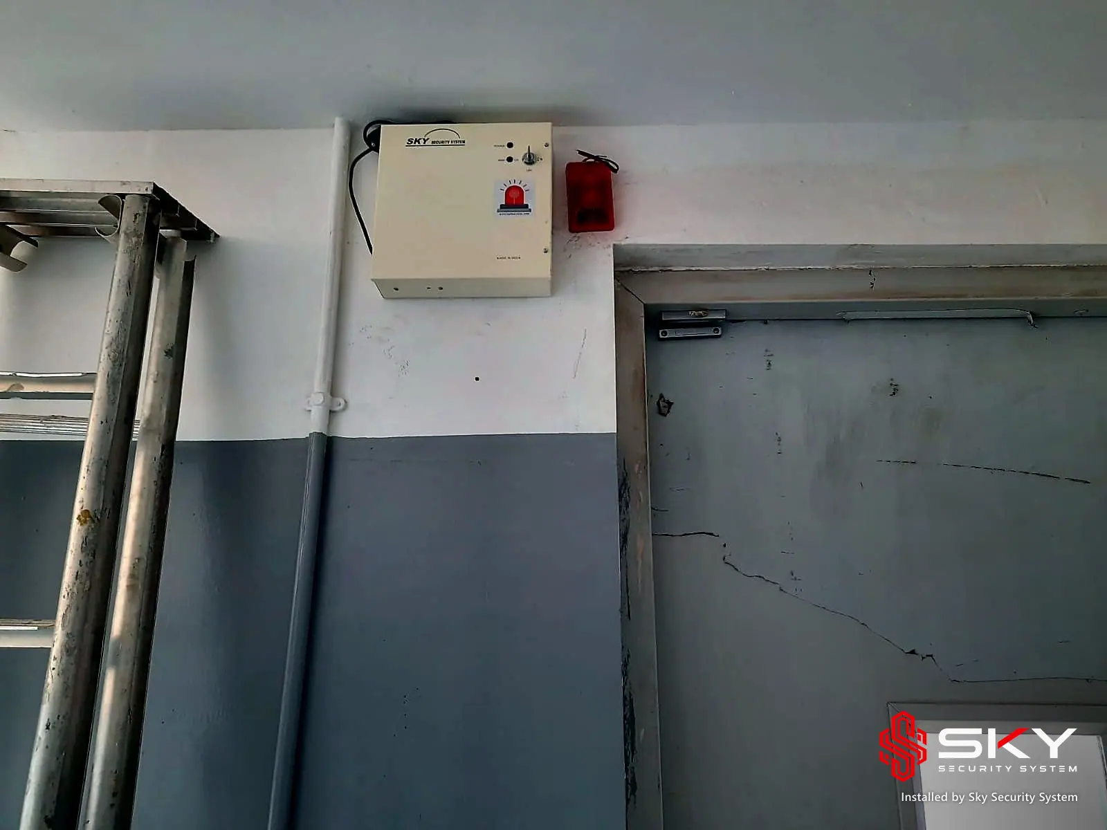 Fire alarm panel above a factory door at an industrial plant, Chakan, Pune. Security and ELV work by Sky Security System.