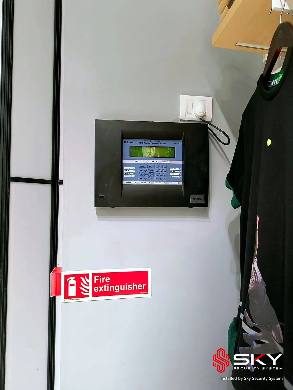 Fire alarm panel and extinguisher sign at a fashion retail. Security and ELV work by Sky Security System.